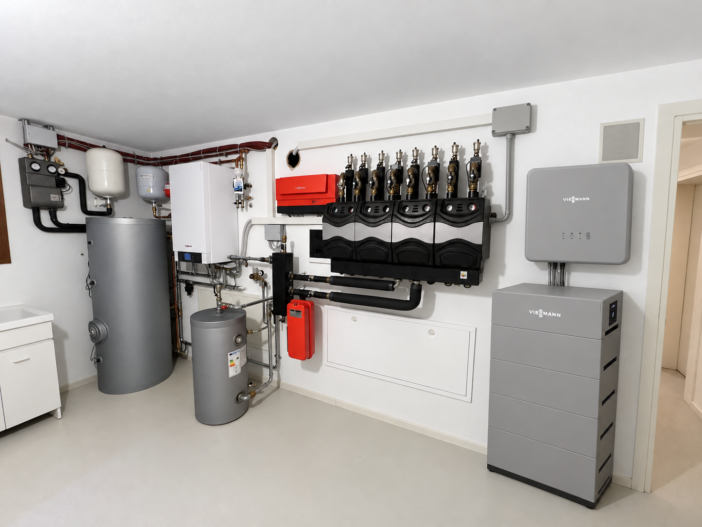 locale tecnico con bollitori, pompa di calore a parete, gruppi di pompaggio, inverter a parete e batteria di accumulo a torre